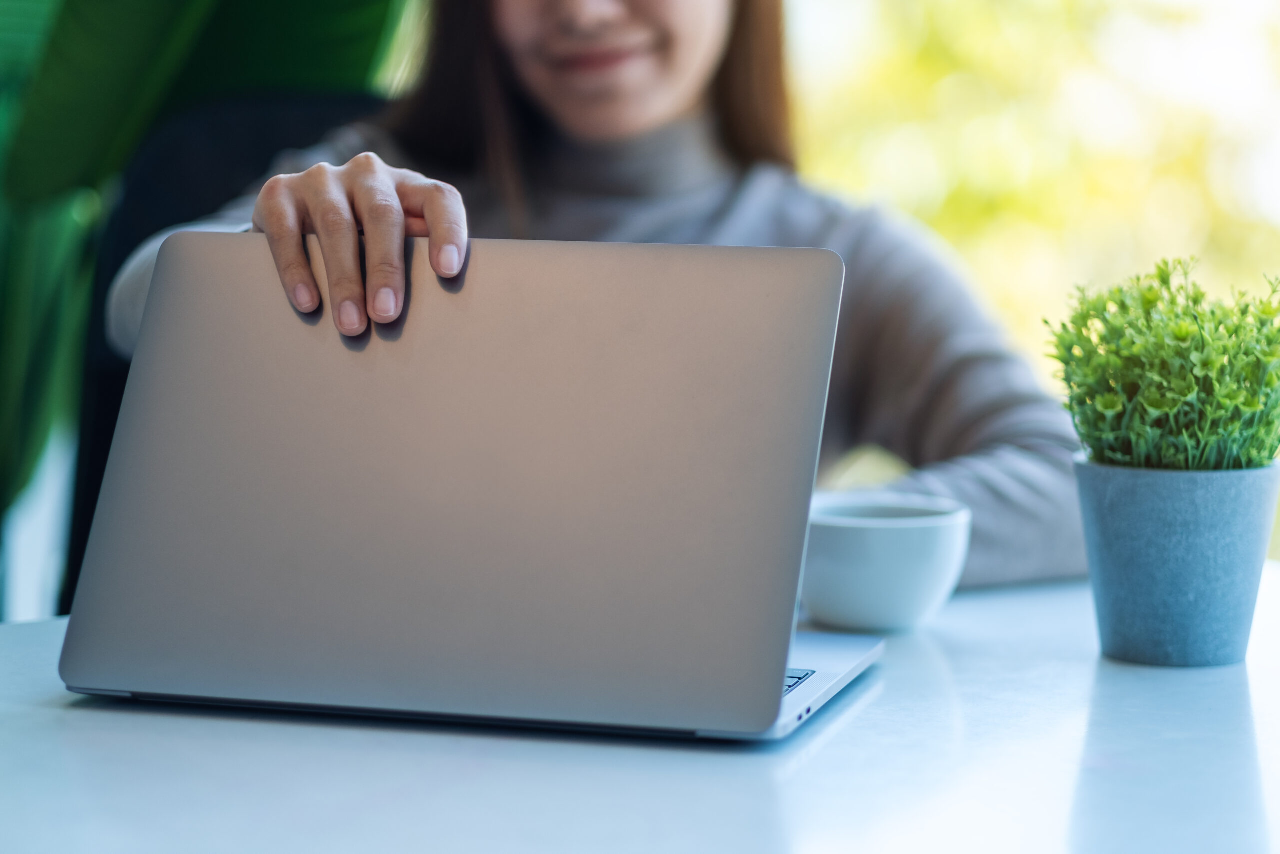 Frau klappt Laptop auf